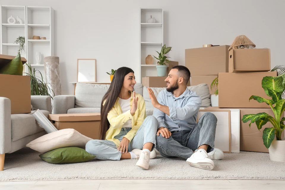 Deux livreurs en uniforme bleu portant masques chirurgicaux transportent des colis en carton devant un camion de livraison blanc